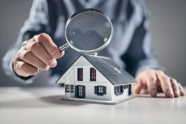 A magnifying glass held over a model house