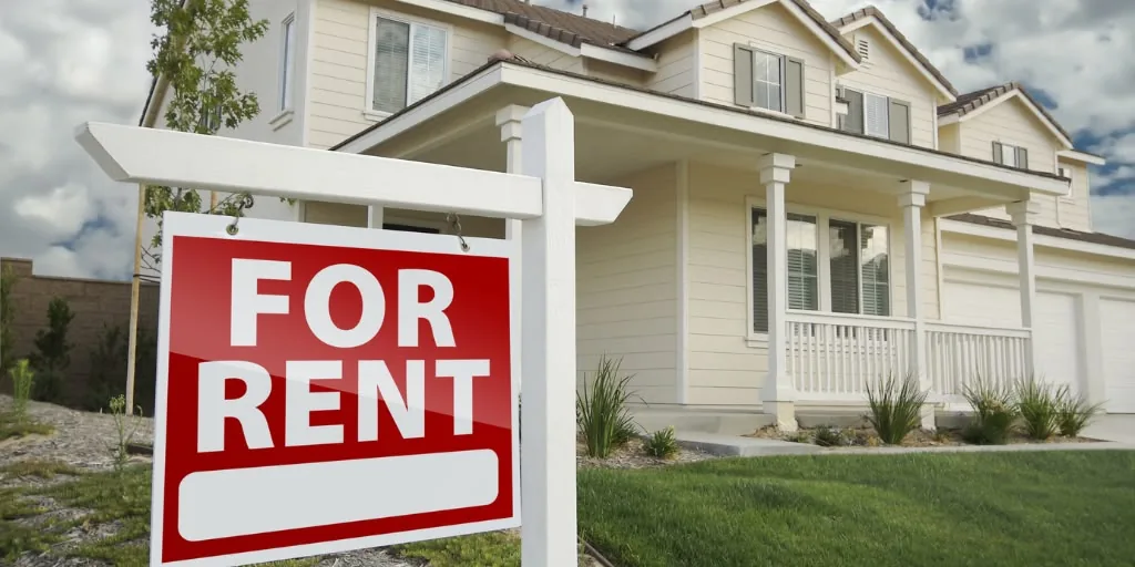 A red “For Rent” sign outside a house